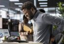 Hombre con dolor lumbar por mala postura en teletrabajo, necesidad de accesorios ergonómicos